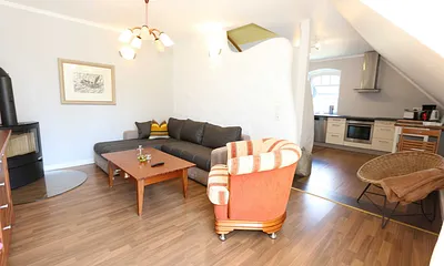 Wohnbereich mit großer Couchecke, Couchtisch, Leselampe, Sideboard, Smart-TV und Mini-Stereo-Anlage