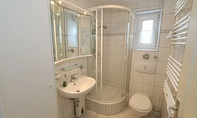 Badezimmer mit Waschtisch, WC, Fön und Dusche