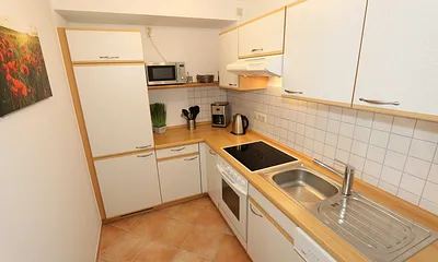 Küche mit Geschirrspüler, Cerankochfeld, Backofen, Kühlschrank mit Gefrierfächer, Mikrowelle, Kaffeemaschine, Senseopad-Maschine, Wasserkocher, Toaster sowie diverse Küchenutensilien