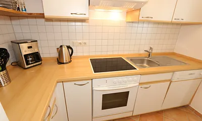 Küche mit Geschirrspüler, Cerankochfeld, Backofen, Kühlschrank mit Gefrierfächer, Mikrowelle, Kaffeemaschine, Senseopad-Maschine, Wasserkocher, Toaster sowie diverse Küchenutensilien