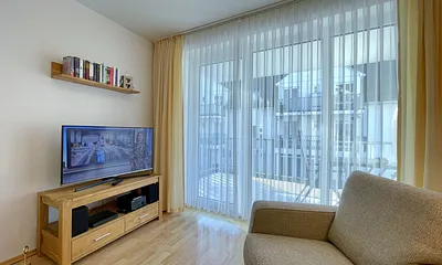 Wohnbereich mit gemütlicher Couch, Couchtisch, kleiner Anrichte, Leselampe, LCD-Flachbildschirm, Blu-Ray-Player sowie Radio/CD-Player