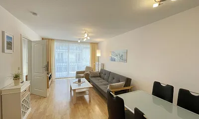 Wohnbereich mit gemütlicher Couch, Couchtisch, kleiner Anrichte, Leselampe, LCD-Flachbildschirm, Blu-Ray-Player sowie Radio/CD-Player