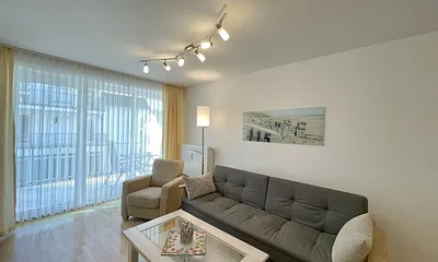 Wohnbereich mit gemütlicher Couch, Couchtisch, kleiner Anrichte, Leselampe, LCD-Flachbildschirm, Blu-Ray-Player sowie Radio/CD-Player