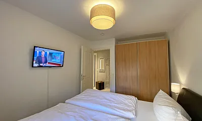 Schlafzimmer mit Echtleder-Doppelbett in Komforthöhe (2 x 0,90 m x 2,00 m), mit Nachttischablagen, Insektenschutzgittern, Verdunklungsmöglichkeit und einen großem Kleiderschrank