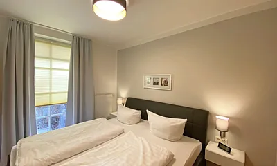 Schlafzimmer mit Echtleder-Doppelbett in Komforthöhe (2 x 0,90 m x 2,00 m), mit Nachttischablagen, Insektenschutzgittern, Verdunklungsmöglichkeit und einen großem Kleiderschrank