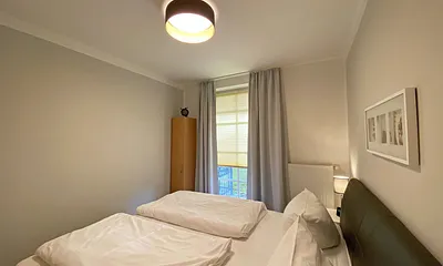 Schlafzimmer mit Echtleder-Doppelbett in Komforthöhe (2 x 0,90 m x 2,00 m), mit Nachttischablagen, Insektenschutzgittern, Verdunklungsmöglichkeit und einen großem Kleiderschrank