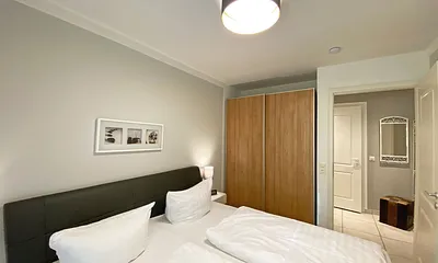 Schlafzimmer mit Echtleder-Doppelbett in Komforthöhe (2 x 0,90 m x 2,00 m), mit Nachttischablagen, Insektenschutzgittern, Verdunklungsmöglichkeit und einen großem Kleiderschrank