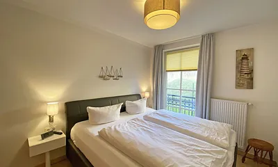 Schlafzimmer mit Echtleder-Doppelbett in Komforthöhe (2 x 0,90 m x 2,00 m), mit Nachttischablagen, Insektenschutzgittern, Verdunklungsmöglichkeit und einen großem Kleiderschrank