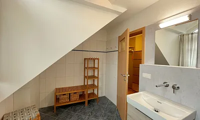 Badezimmer mit Dusche, WC, Fön, Waschmaschine (Münzgerät) sowie Fußbodenheizung und Handtuchtrockner