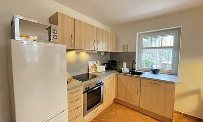 Küche mit Cerankochfeld, Backofen, Kühl/Gefrierkombi, Mikrowelle, Spülmaschine, Kaffeemaschine, Wasserkocher, Mixer und Toaster