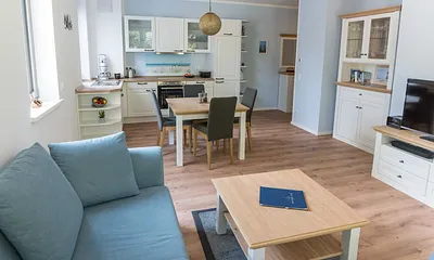 offener Wohnbereich mit bequemer Couch (Aufbettung 3. Person 1,60 m x 2,00 m), Sessel, Couchtisch, Stehlampe, Sideboard, Vitrine, Smart-TV sowie ein DAB Radio mit Bluetooth