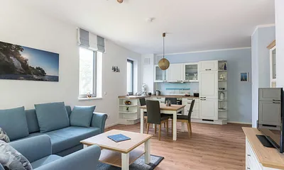 offener Wohnbereich mit bequemer Couch (Aufbettung 3. Person 1,60 m x 2,00 m), Sessel, Couchtisch, Stehlampe, Sideboard, Vitrine, Smart-TV sowie ein DAB Radio mit Bluetooth