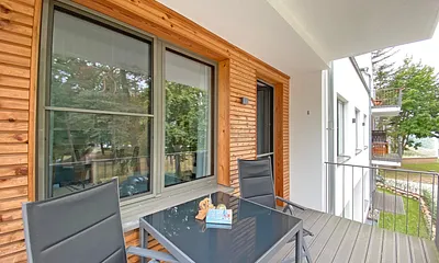überdachter Balkon (Nord) mit Sitzgarnitur und Blick auf den Park