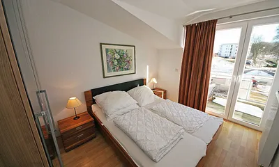 Schlafzimmer mit Doppelbett, Nachttischkonsolen und einen großen Kleiderschrank