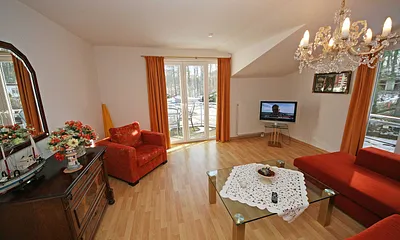 gemütliches Wohnzimmer mit Eckcouch (Aufbettung für die 3. Person), Sessel, Flachbild TV, Couchtisch sowie eine Anrichte