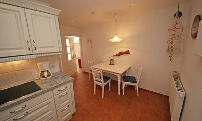 offene Küchenzeile mit Ceranfeld, Backofen, Geschirrspüler, Kühlschrank, Kaffeemaschine, Wasserkocher, Toaster sowie diverse Küchenutensilien