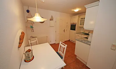 offene Küchenzeile mit Ceranfeld, Backofen, Geschirrspüler, Kühlschrank, Kaffeemaschine, Wasserkocher, Toaster sowie diverse Küchenutensilien