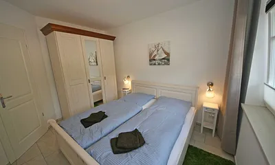 Schlafzimmer mit Doppelbett und Kleiderschrank