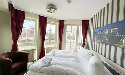 Schlafzimmer mit Doppelbett, Sessel und Kleiderschrank