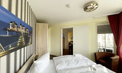 Schlafzimmer mit Doppelbett, Sessel und Kleiderschrank