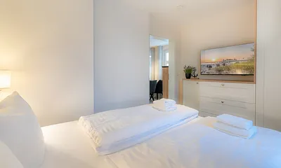 Schlafzimmer mit Doppelbett und TV