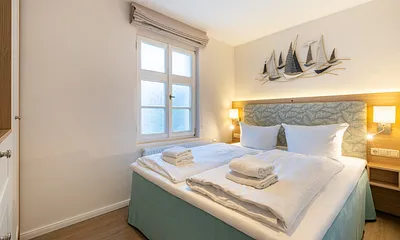 Schlafzimmer mit Doppelbett und TV