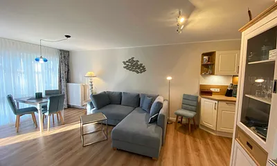 Wohn-/ Essbereich mit gemütlicher Couch (Aufbettung 3. Person, Liegefläche 1,60 m x 2,00 m), Couchtisch, Leselampe, Lowboard mit Smart-TV und einem DAB Radio mit USB-Anschluss und Bluetooth Anschluss 