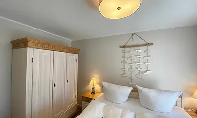 Schlafzimmer mit Doppelbett (1,80 m x 2,00 m), Nachttischablagen mit Lampen und einen Kleiderschrank