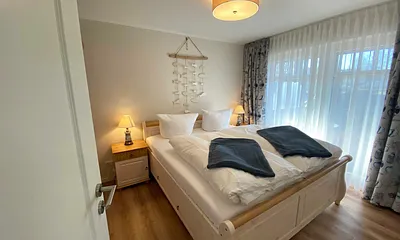 Schlafzimmer mit Doppelbett (1,80 m x 2,00 m), Nachttischablagen mit Lampen und einen Kleiderschrank