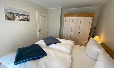 Schlafzimmer mit Doppelbett (1,80 m x 2,00 m), Nachttischablagen mit Lampen und einen Kleiderschrank