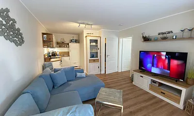 Wohn-/ Essbereich mit gemütlicher Couch (Aufbettung 3. Person, Liegefläche 1,60 m x 2,00 m), Couchtisch, Leselampe, Lowboard mit Smart-TV und einem DAB Radio mit USB-Anschluss und Bluetooth Anschluss 