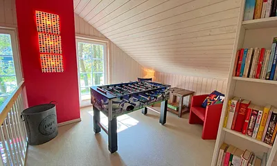 lichtdurchflutete Galerie mit Tisch - Kicker für gesellige „Fußballspiele“, Leseecke mit Sesseln 