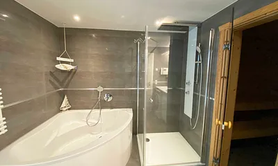 großes Badezimmer mit Fenster, Waschtisch,Wandspiegel, ebenerdiger Regendusche,Wellnesswanne, WC,Haartrockner,Handtuchtrockner,Kosmetikspiegel sowie wohnungseigene Sauna mit Bio-Ofen und LED-Farblicht