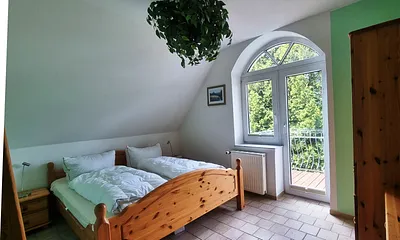 Schlafzimmer mit Balkonzugang und Gartenblick