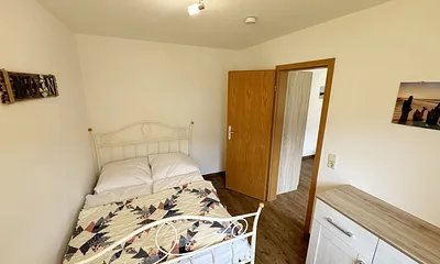 Schlafzimmer mit Doppelbett (1,40 m x 2,00 m), Sideboard, Sessel und Stehlampe (über das Elternschlafzimmer erreichbar)