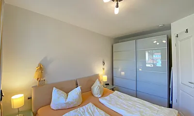 Schlafzimmer mit bequemem Doppelbett (1,80 m x 2,00 m), verstellbaren Lattenrosten, zwei Nachttischablagen, Insektenschutzgitter, Verdunklungsmöglichkeit sowie großer Kleiderschrank mit Safe