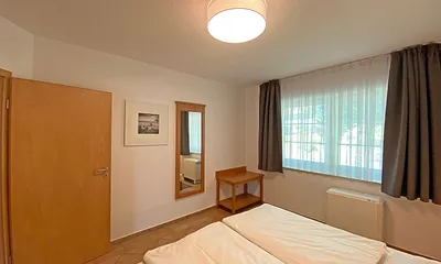 Schlafzimmer mit Doppelbett (1,80 m x 2,00 m), Nachtischablagen und Kleiderschrank