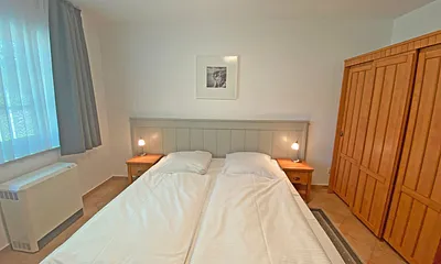 Schlafzimmer mit Doppelbett (1,80 m x 2,00 m), Nachtischablagen und Kleiderschrank