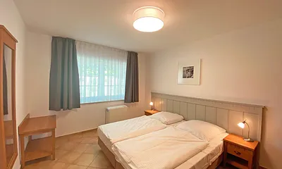 Schlafzimmer mit Doppelbett (1,80 m x 2,00 m), Nachtischablagen und Kleiderschrank