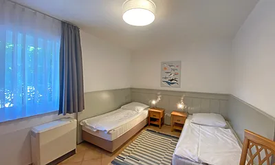 Schlafzimmer mit 2 Einzelbetten (0,90 m x 2,00 m) - auch als Doppelbett stellbar, Nachttischablagen und Kleiderschrank