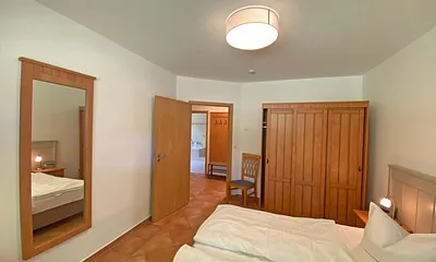 Schlafzimmer mit Doppelbett (1,80 m x 2,00 m), Nachtischablagen und Kleiderschrank 