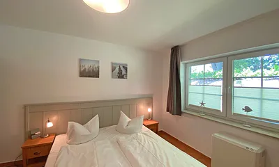 Schlafzimmer mit Doppelbett (1,80 m x 2,00 m), Nachtischablagen und Kleiderschrank 