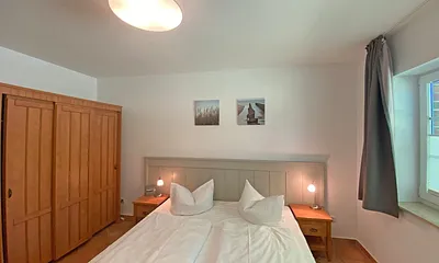 Schlafzimmer mit Doppelbett (1,80 m x 2,00 m), Nachtischablagen und Kleiderschrank 