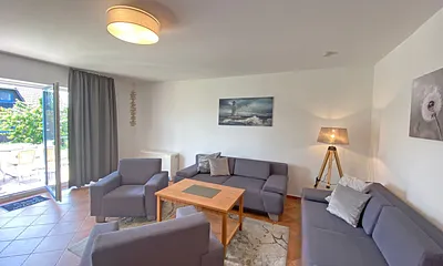 Wohnbereich mit Massivmöbeln, Stehlampe, zwei Sessel, zwei Couchen, 42 Zoll LCD-TV und ein CD/ Blu-Ray-Player