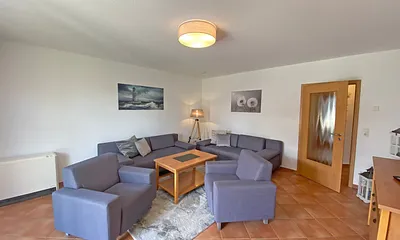 Wohnbereich mit Massivmöbeln, Stehlampe, zwei Sessel, zwei Couchen, 42 Zoll LCD-TV und ein CD/ Blu-Ray-Player