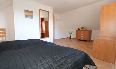 Schlafzimmer mit Doppelbett (1,80 m x 2,00 m), verstellbaren Lattenrosten, Nachttischablagen mit Leselicht und Kleiderschrank 