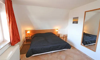 Schlafzimmer mit Doppelbett (1,80 m x 2,00 m), verstellbaren Lattenrosten, Nachttischablagen mit Leselicht und Kleiderschrank 