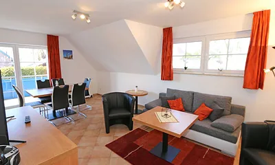 Wohnzimmer mit Schlafcouch (Aufbettung für 5./6. Person 1,37 m x 1,97 m), Stehlampe, zwei Sessel, Smart-TV sowie ein CD und Blu-Ray-Player