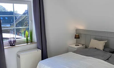 Schlafzimmer mit Doppelbett (1,80 m x 2,00 m), Nachttischablagen, Kleiderschrank und großem Spiegel sowie Insektenschutz