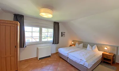 Schlafzimmer mit Doppelbett (1,80 m x 2,00 m), Nachtischablagen und Kleiderschrank 